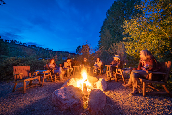 guests sitting by a campfire on a dude ranch vacation