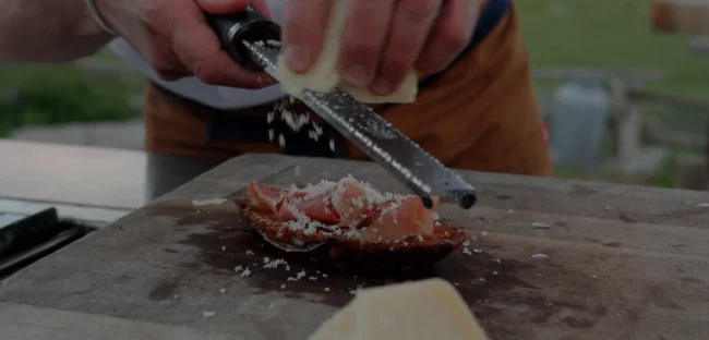 Pan Con Tomate Recipe Parmesan cheese being grated on Pan Con Tomate