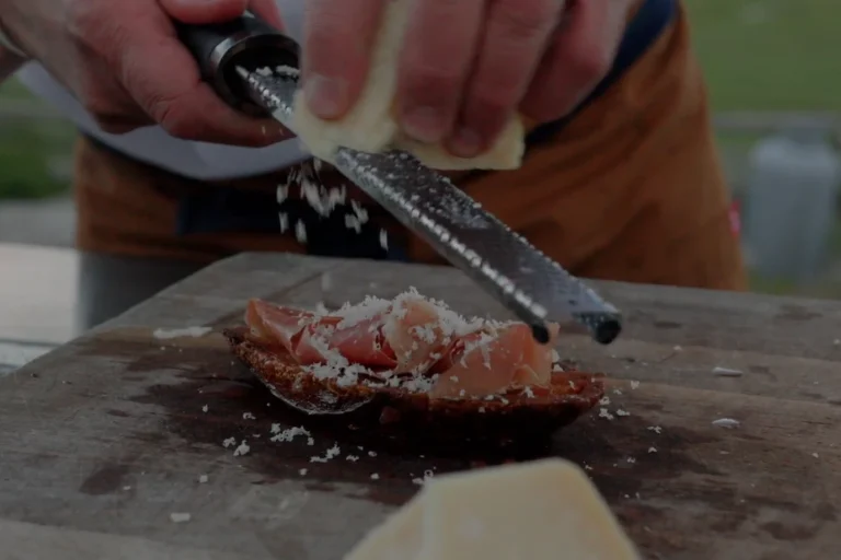 Pan Con Tomate Recipe Parmesan cheese being grated on Pan Con Tomate