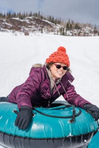 older woman tubing on the snow